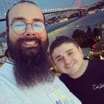 two friend clicking image behind bridge