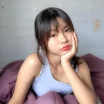 a girl image wearing white shirt with red lips and hand on his face like in thinking posture